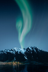 Wall Mural - Aurora borealis and mountain landscape with small norwegian village