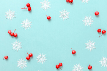 winter design. white snowflakes, red berry in christmas composition on pastel blue background for gr