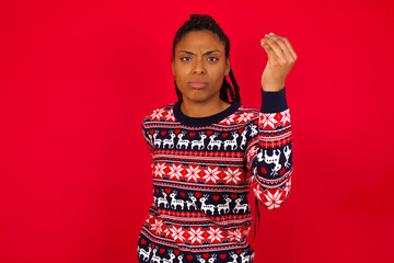 Wall Mural - Young beautiful African American woman standing against red background angry gesturing typical Italian gesture with hand, looking to camera