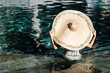 Woman in big straw hat relaxing at pool. Wellness and relaxation concept for summer luxury vacations.