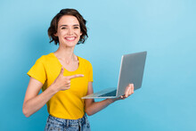 Photo Of Pretty Girl Hold Netbook Shiny Smile Indicate Finger Wear Yellow T-shirt Isolated Blue Color Background