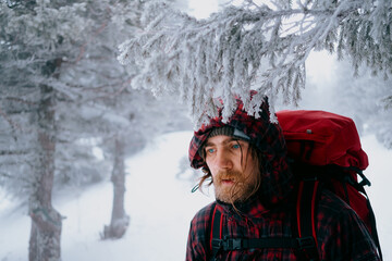 Portrait of a male traveler in the winter forest