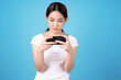 © Basicdog - Asian woman holding a smartphone in hand, Isolated on a blue background.