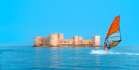 Wall Mural - Windsurfer Surfing The Wind On Waves - The maiden's castle (Kiz Kalesi) Mersin Turkey