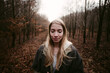 © Chris Zielecki/Stocksy - Long haired woman in warm clothes standing among trees with peacefully closed eyes