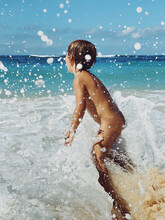 Little Boy Swimming In A Ocean Splashes