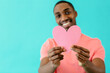 © Carlos David - Portrait of an smiling young man holding pink heart for valentineÕs day love, give your heart concept