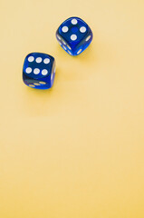 Canvas Print - Vertical shot of blue dice isolated on yellow background