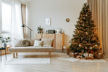 Bright Interior Of The Living Room With A Sofa And A Large Christmas Tree. New Year's Interior.