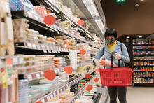 Woman Wearing Face Mask Shopping In Supermarket