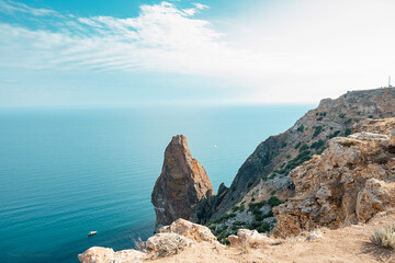 A beautiful view from the cliff to the water surface, where there are rocky shores.