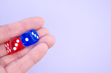 Canvas Print - Closeup shot of a hand holding red and blue dice isolated on white background