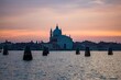 Sunset view of a cathedral in Venice, Italy with the canal in the foreground