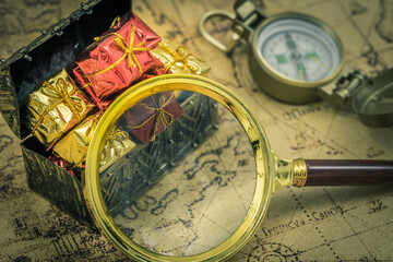 Aufkleber - The treasure hunt. A magnifying glass and a compass next to a chest full of treasures. Old map, Vintage style