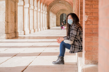 Canvas Print - new normal tourism and holidays travel - young and beautiful Asian Chinese woman in face mask enjoying city tour walking around historic district on sunny winter day during covid19