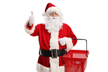 Poster - Happy Santa claus holding a shopping basket and gesturing thumbs up