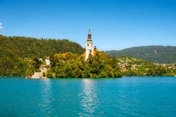 Cozy Lake Bled in summer with the Juliet Alps in the background of the beautiful castle