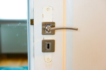 Canvas Print - Closeup of a metal handle of an opened wooden door