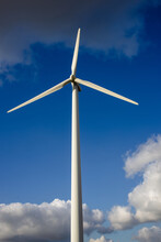Closeup Vertical Shot Of A Single Windmill For Electric Power Production With A Cloudy Sky Behind