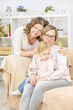 © Ermolaeva Olga - Two young women are sitting in the living room on the sofa with a child and smiling to their daughter. Gay lesbian couple at home with a baby. Lesbian family