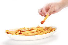 Man's Hand Picking A Piece Of French Fries With Catsup Isolated On White Background
