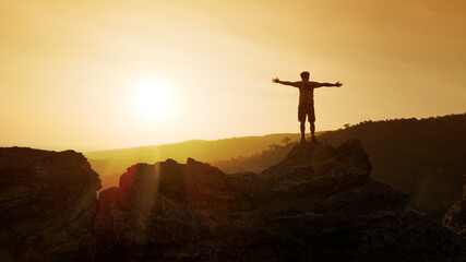 Wall Mural - man open arms on top of mountain with sunset or sunrise background