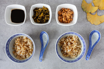 Natto meal in decorative bowls. Ingredients: rice, soy sauce, natto soybeans, pickled mustard greens. Flat lay view.