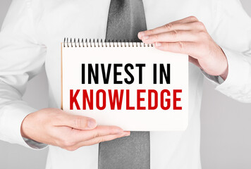 Poster - Businessman with notebook with text INVEST IN KNOWLEDGE