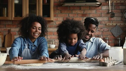 Wall Mural - Full African family married couple and daughter preparing holiday cake flatten dough with rolling pins enjoy process, communication while cooking together. Having fun, hobby, teaching of child concept