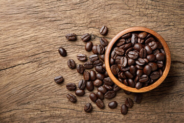 Wall Mural - Flat lay (top view) of Roasted coffee beans in wooden bowl on wood background.