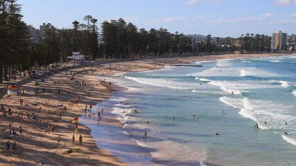 Poster - Sands and waves of Manly beach in Sydney – zoom out over people in 4k.
