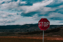 Closeup Shot Of A Stop Sign Against A Landscape