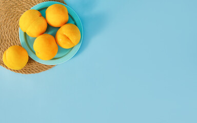 Wall Mural - Yellow peaches on a light blue background