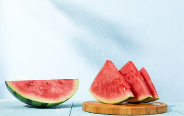 Canvas Print - Closeup shot of watermelon slices on a wooden board on a light blue background