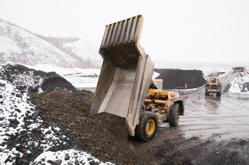 Wall Mural - Dump trucks at work. Mining in highlands