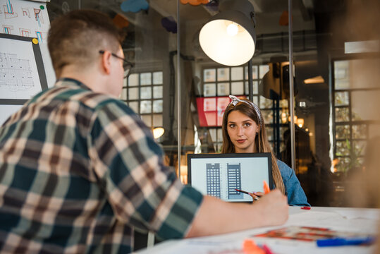 Female designer holding laptop computer with architectural blueprint on laptop screen
