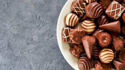 Canvas Print - chocolate candies rotating- top view and copy space