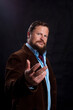 © idea_studio - Stylish bearded man dressed in suit studio portrait on black background.