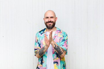 bald man smiling and looking friendly, showing number two or second with hand forward, counting down