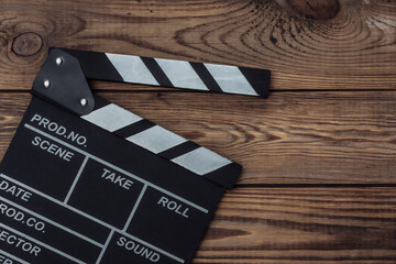 Film clapper board on wooden background. Cinema industry, entertainment. Top view