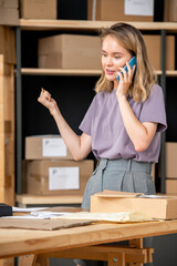 Aufkleber - Young female manager of online shop calling one of clients after making order