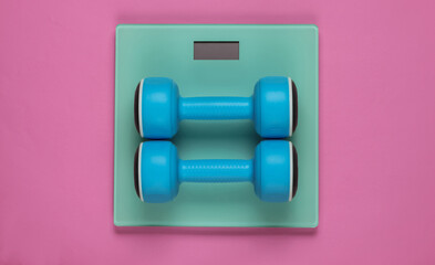 Wall Mural - Floor scales and dumbbell on  pink background. Sport concept, fitness training. Studio shot. Top view