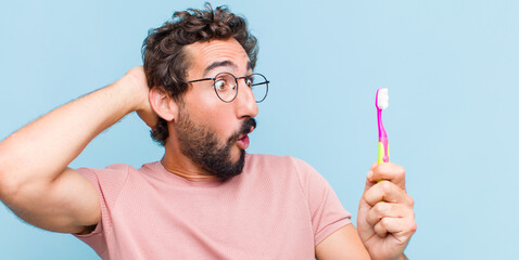 Poster - young bearded man with open mouth, looking horrified and shocked because of a terrible mistake, raising hands to head