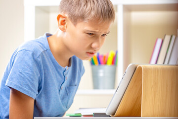 Confused upset teenage boy stuck with homework. Kid having learning problem. Learning difficulties, online education concept