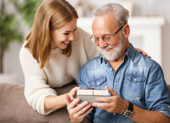 Wall Mural - Happy father and daughter examining gift.