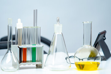 Poster - Labaratory glasses are located on table. Test tubes of various shapes. Multi-colored liquid is poured in test tubes. Concept - production of laboratory glassware. Laboratory glasses for research