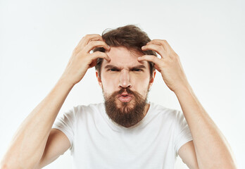 A young man in a white T-shirt gestures with his hands emotions irritability stress