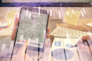 Multi exposure of man's hands holding and using a phone and financial chart drawing. Market analysis concept.