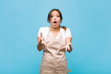 Wall Mural - young hispanic woman feeling extremely shocked and surprised, anxious and panicking, with a stressed and horrified look