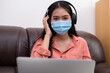 © PK Studio - woman in face mask with laptop during Learning at home